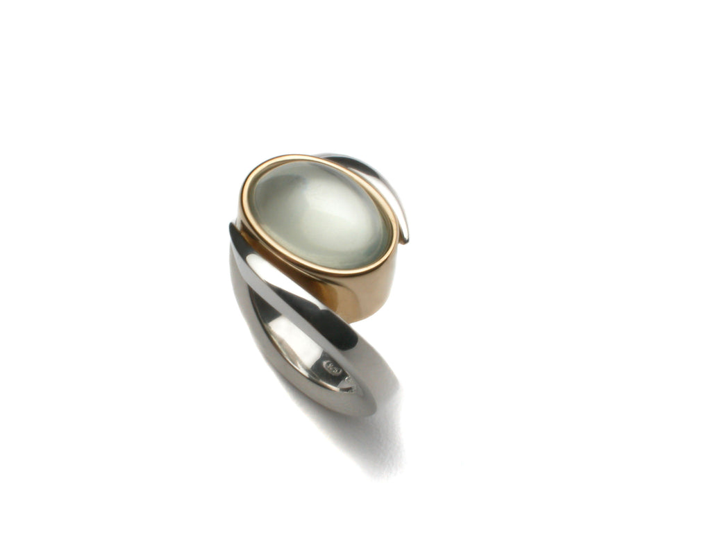 Sterling silver and eighteen karat yellow gold holding an oval Moonstone cabochon. Price inquiry. $0.00