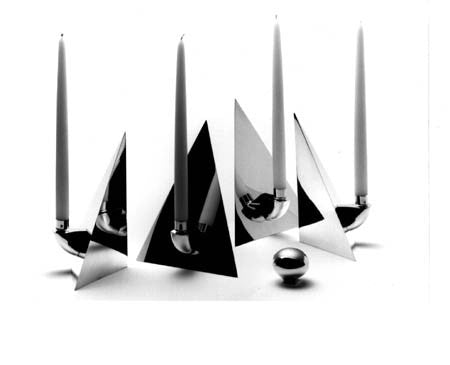 An impressive piece of modern design! a candelabrum topped with a sphere. 
Solid sterling silver. A mirror-bright four-sided pyramid breaks apart into 4 free standing three-sided pyramids, each with its own candleholder. Height 10.5