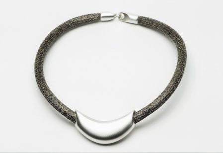 Necklace in sterling silver with a tubular puzzle clasp on steel mesh cord. $720.00
